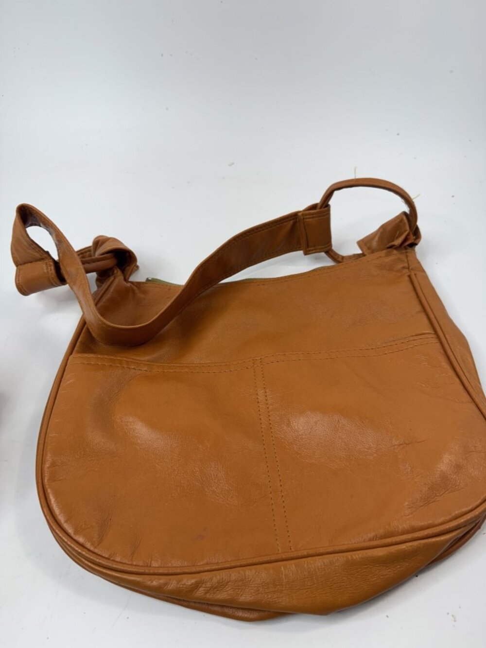 Brown Leather Shoulder Bag With Zipper Closure And Knotted Strap Design